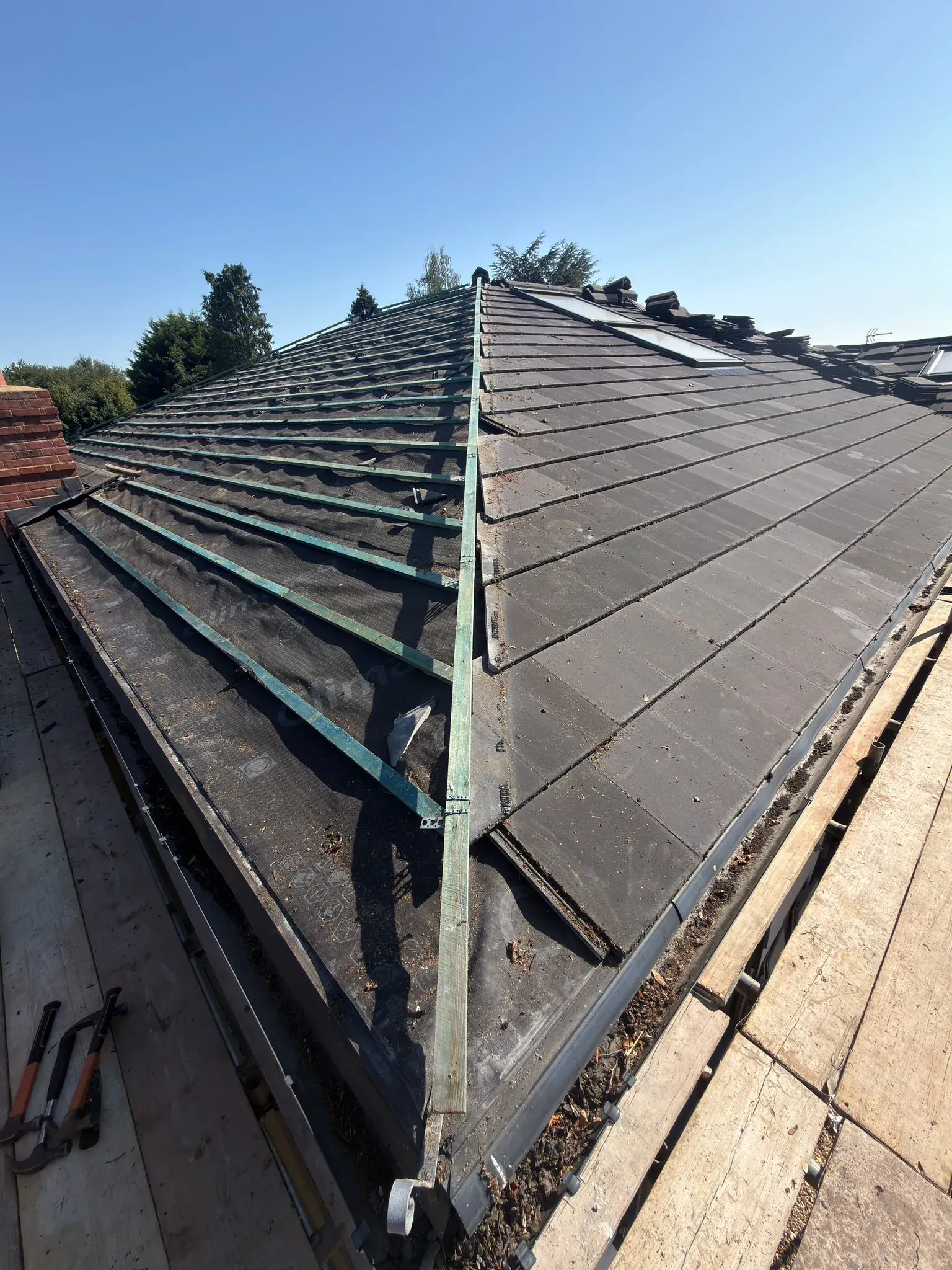 Sections of the existing roof covering removed, exposing membrane and battens during a roof replacement in Watford, Hertfordshire