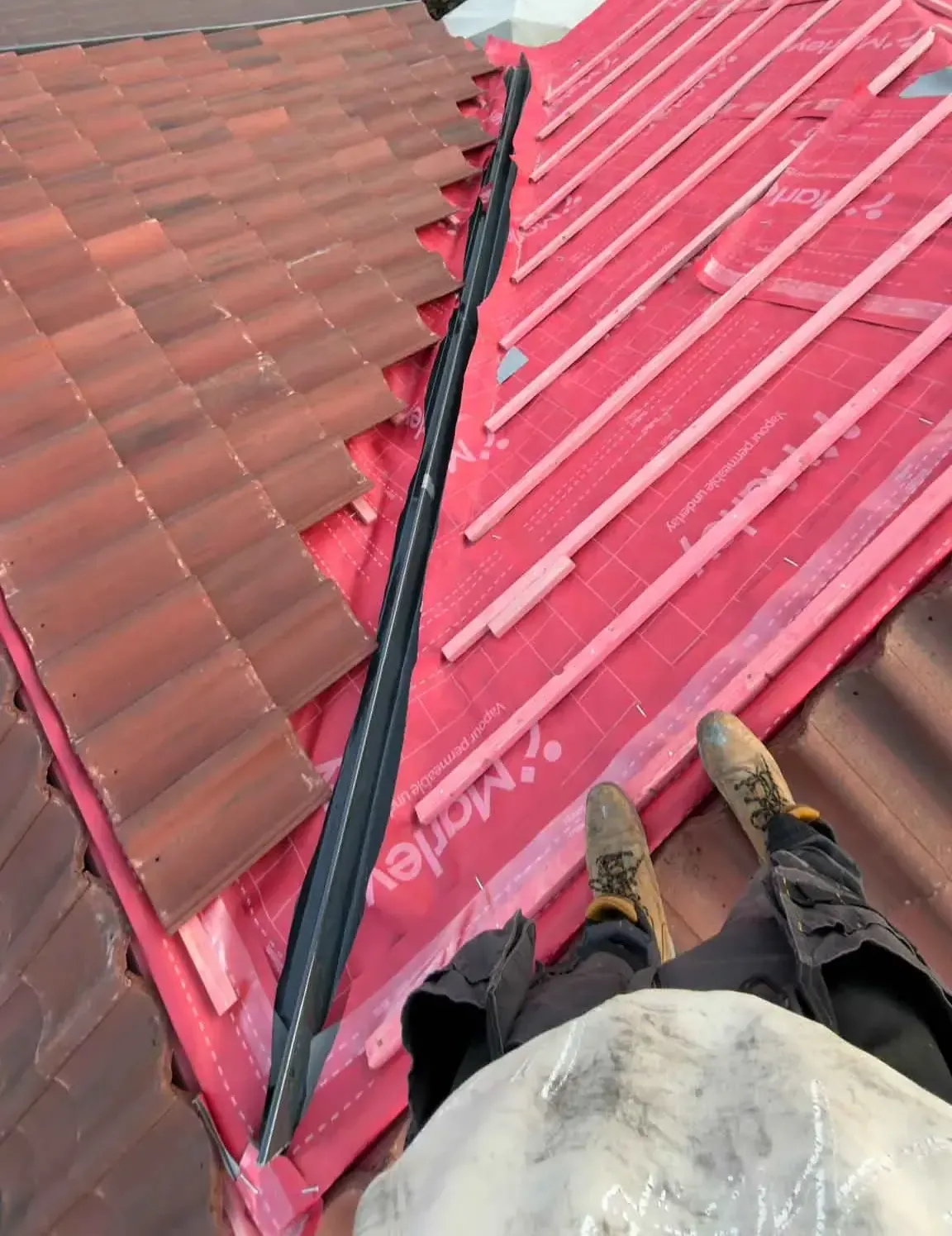 New roofing membrane and battens with new tiles being laid on a roof in Wokingham, Berkshire