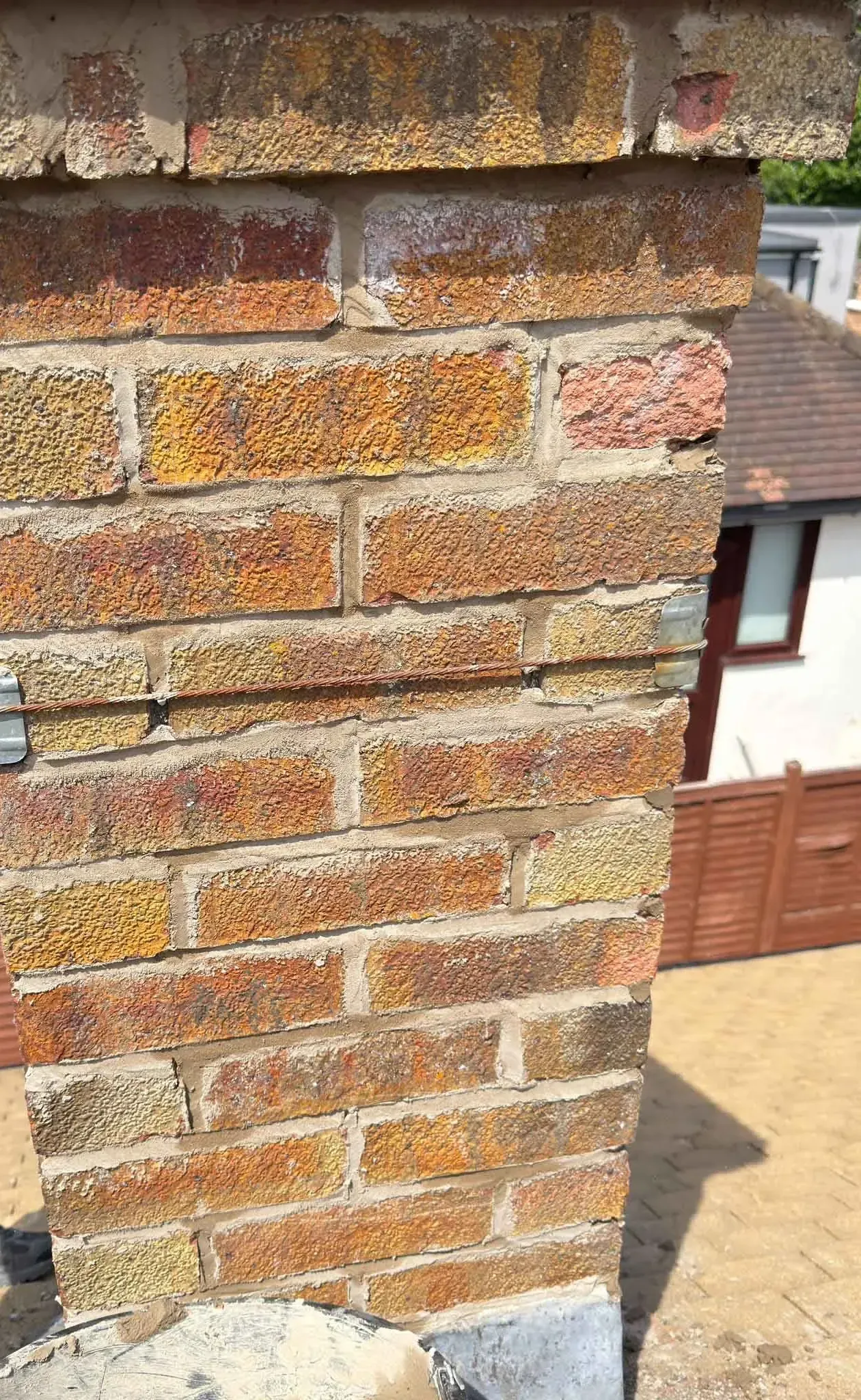 Close-up of chimney brickwork with freshly pointed mortar joints in Harrow, Greater London