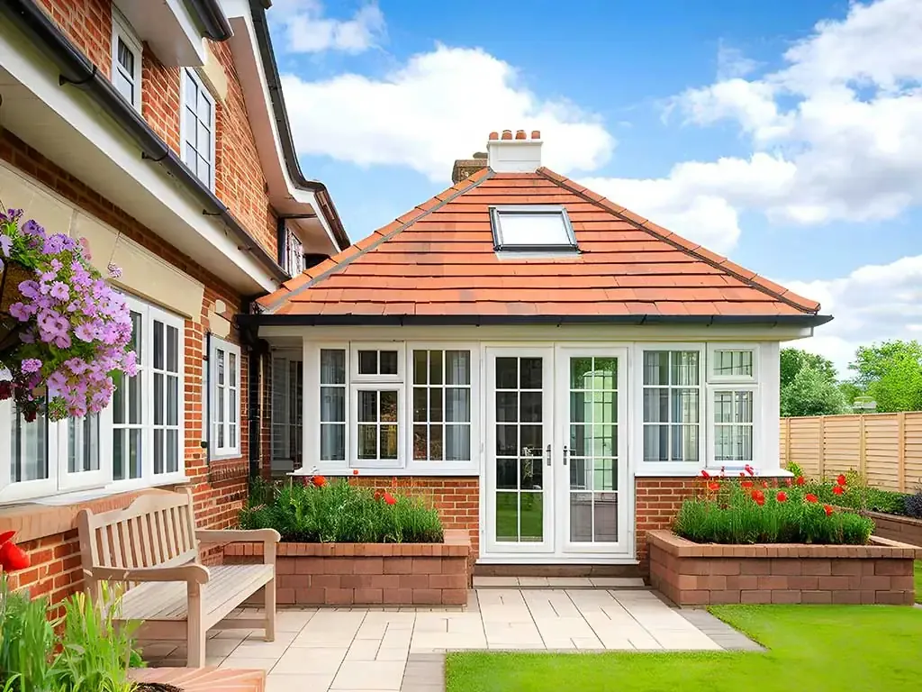A tiled conservatory roof with a roof window and white-framed glazing