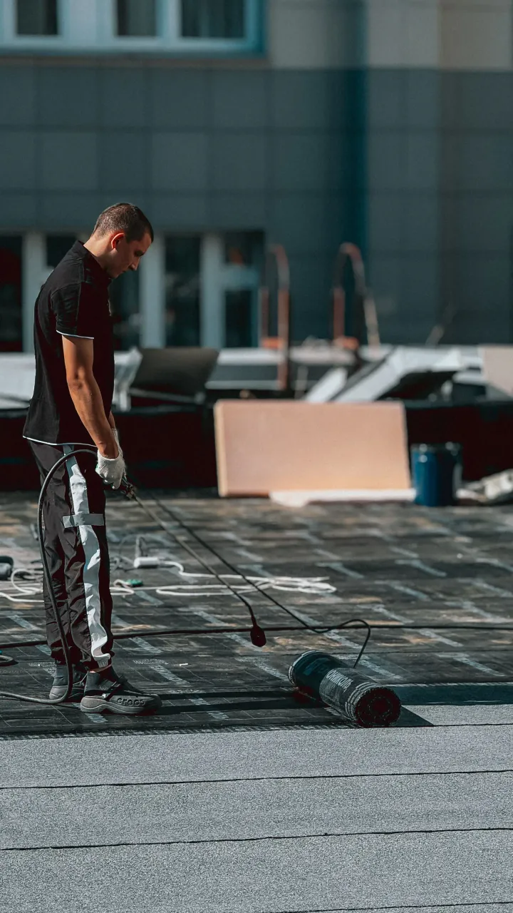 Roofer installing a bituminous membrane on a flat roof