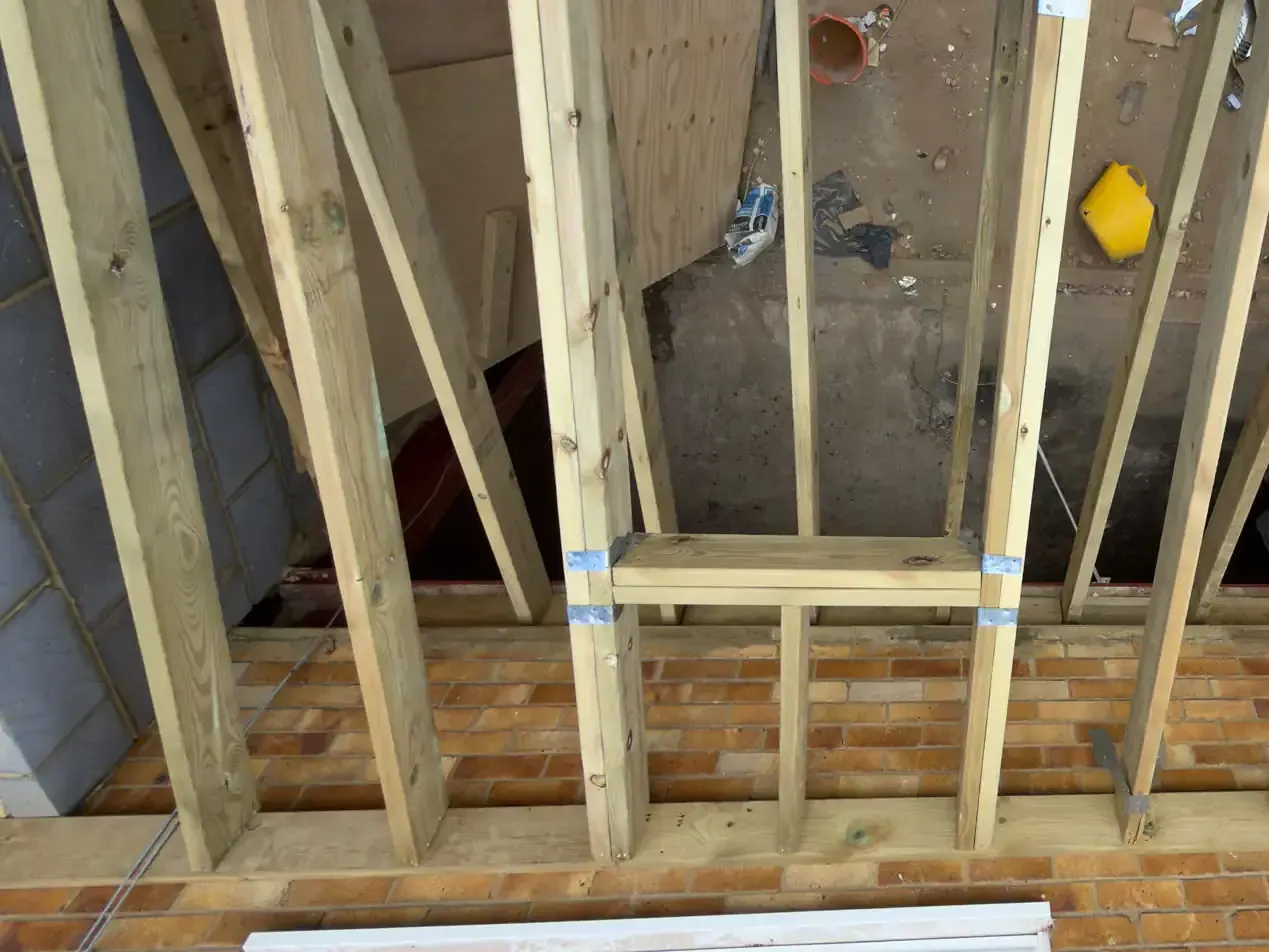 Timber rafters and a framed dormer opening during roof construction in Redhill