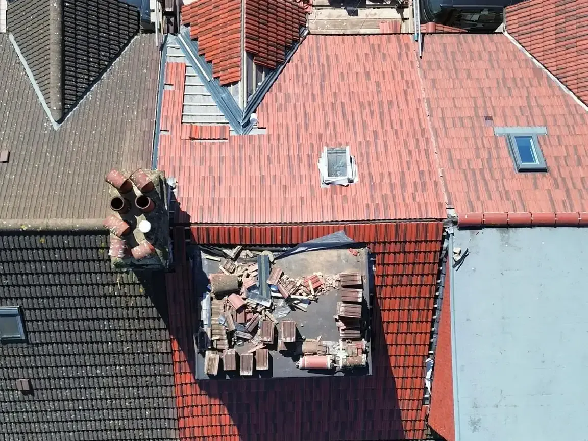 Aerial roof-only view of red tiled covering across a terraced roof in Reigate