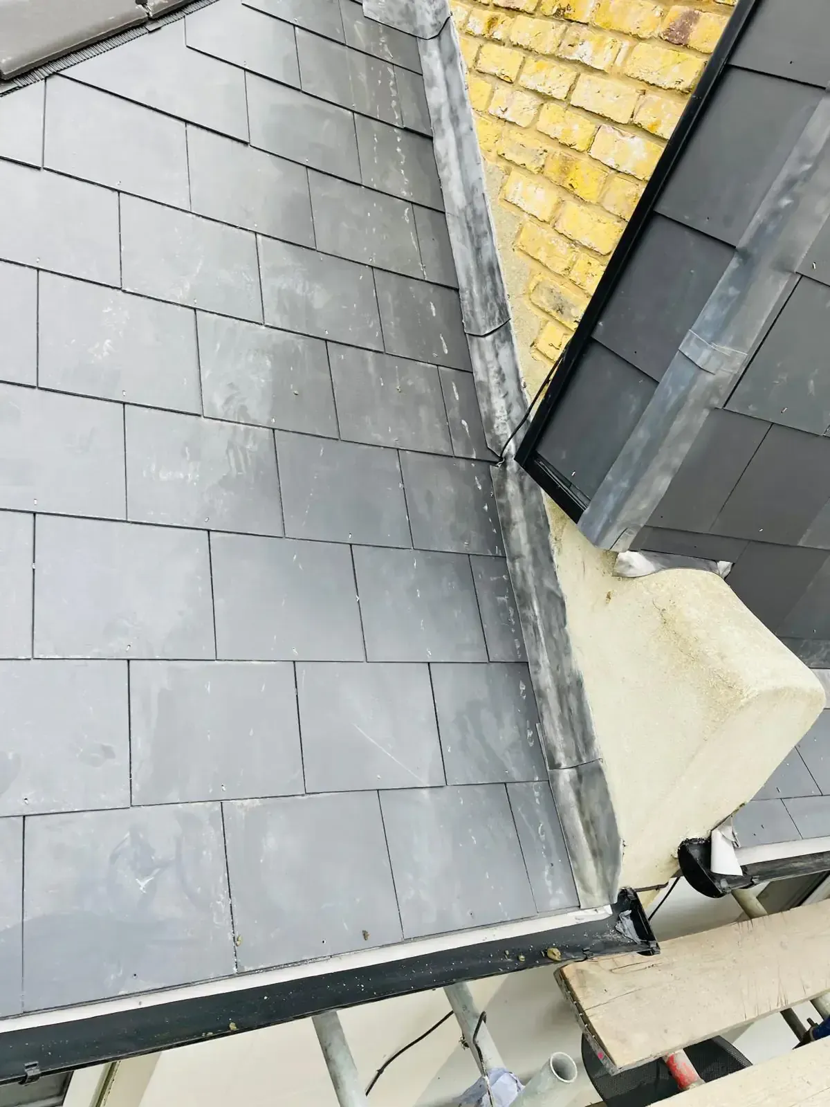 Slate-format roof covering and flashing at roof junctions in Woking, Surrey