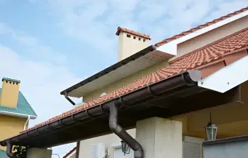 White fascia boards and dark guttering beneath a tiled roof